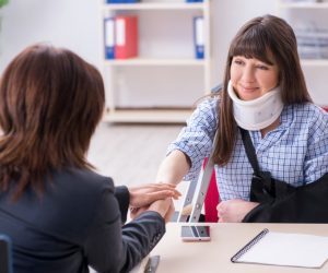 Woman with injured arm talking to her lawyer