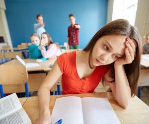 Young girl suffering from bullying in the classroom