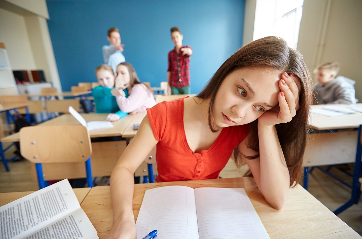 Young girl suffering from bullying in the classroom