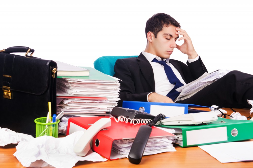 businessman at his desk stressed about clutter