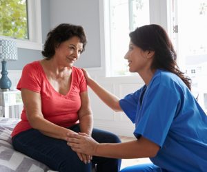 Caregiver comforting a female patient with dementia