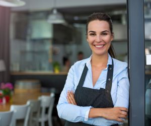 smiling restaurant owner beside the door