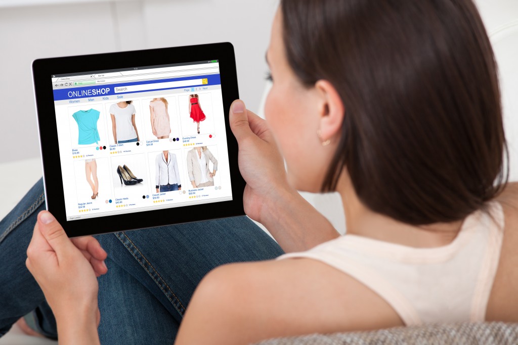 Close-up Of Woman Doing Online Shopping On Digital Tablet At Home