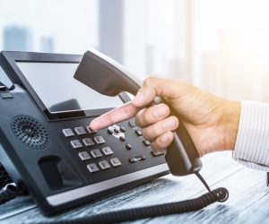 hand of a businessperson dialing on VoIP