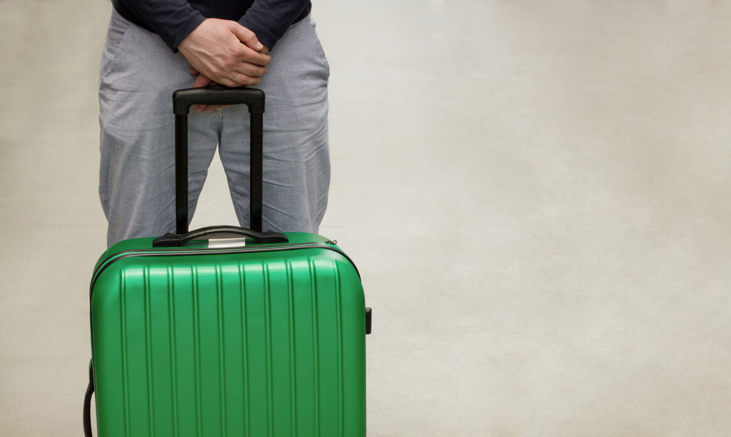 holding a green luggage