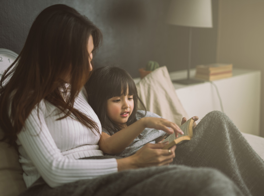 Mom reading books along with her child