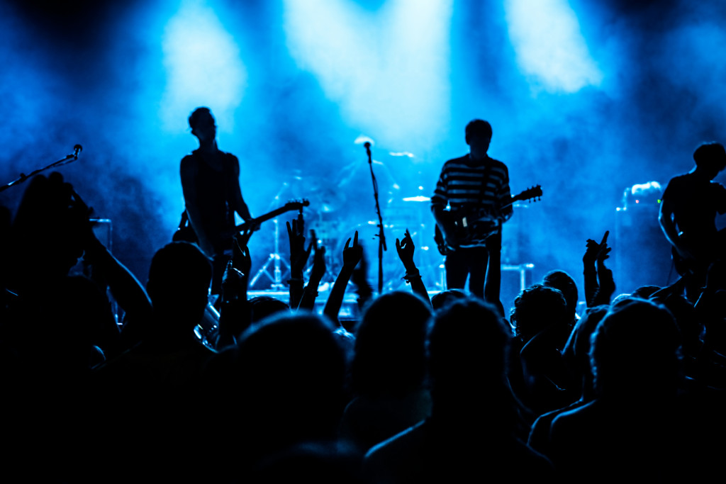 Band singing and playing instruments on stage in a concert