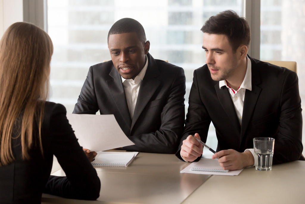 A woman on a job interview with two businessmen in an office