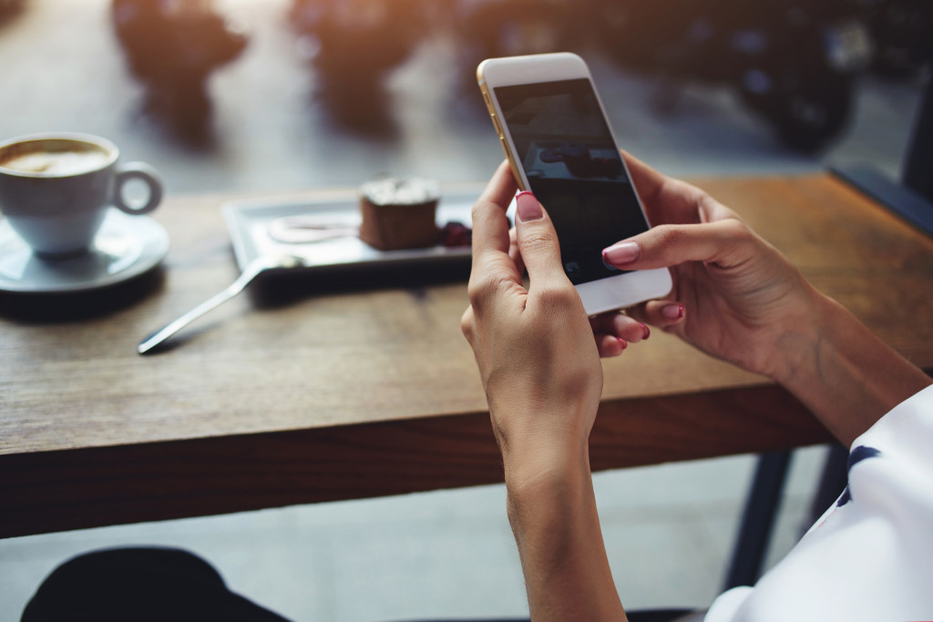 a man in a coffee shop taking time to use his phone