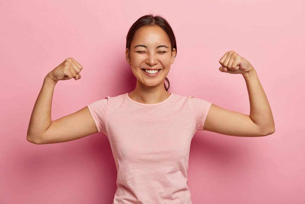 A smiling woman flexing her biceps