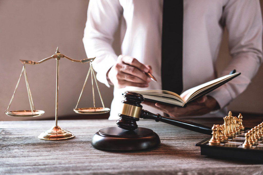 Gavel on wooden table and lawyer working with agreement in courtroom