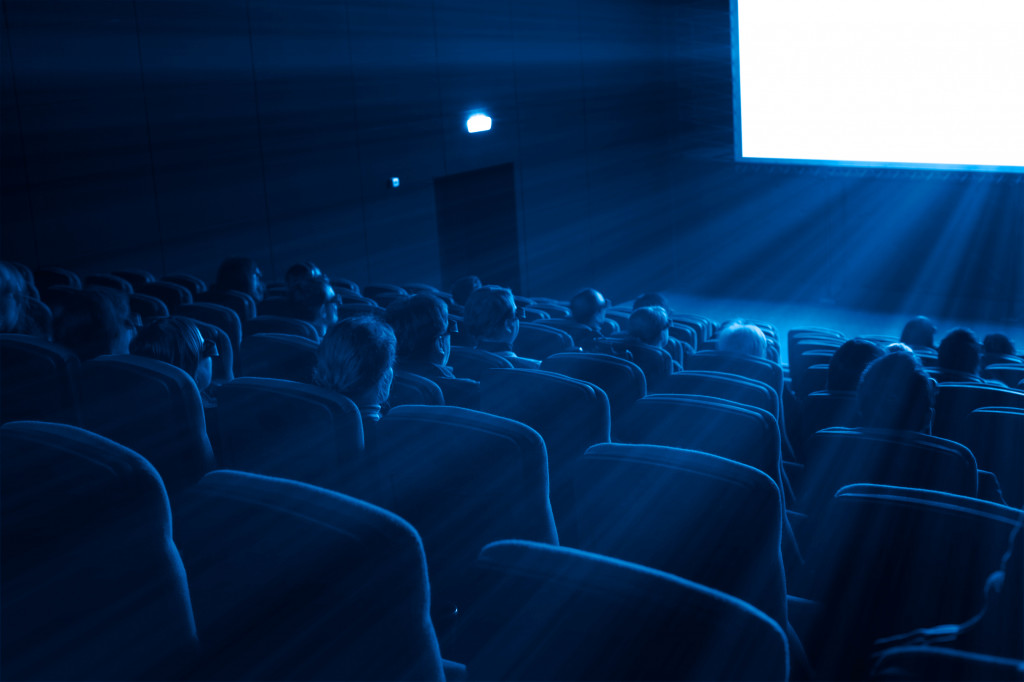 a movie theater with people watching on the screen