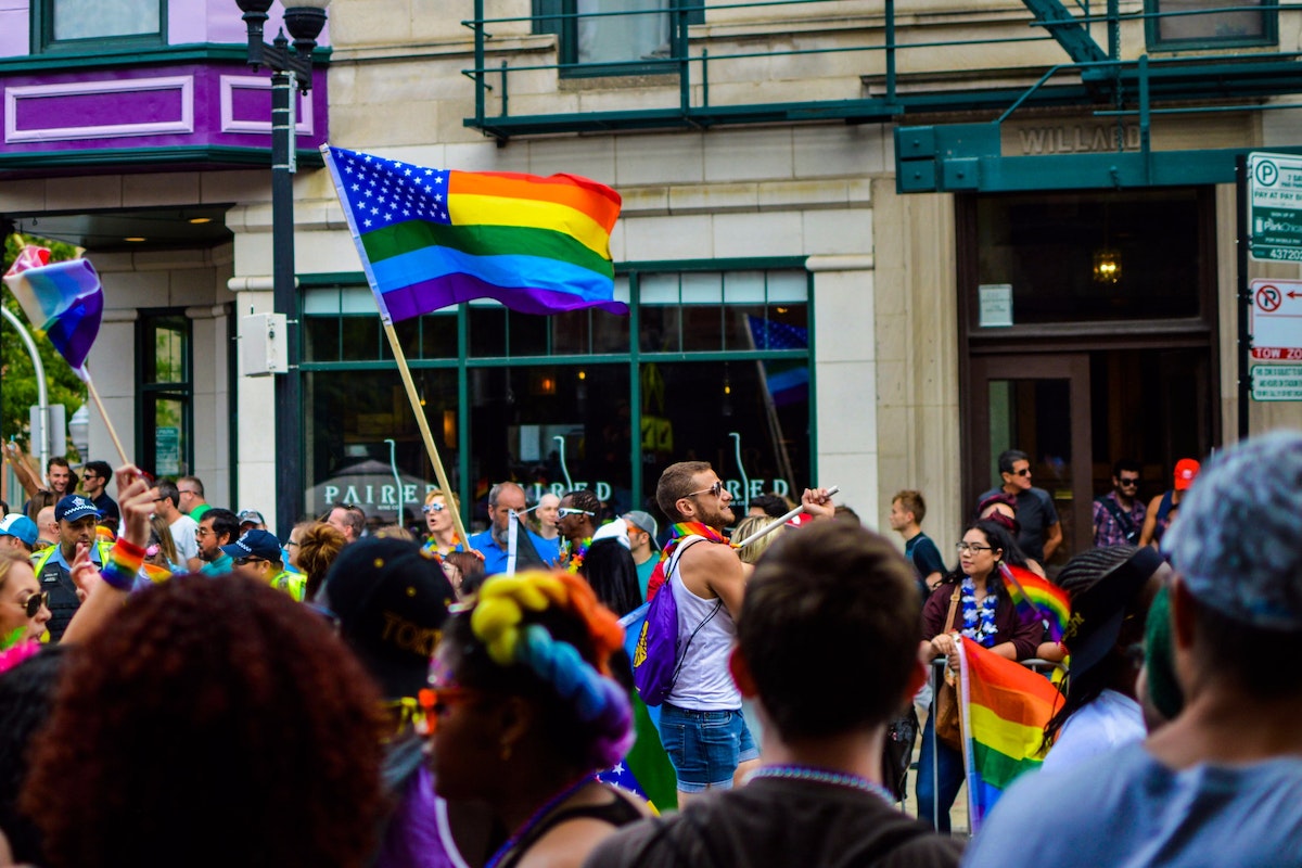 People Gathered Near Building Holding Flag at Daytime