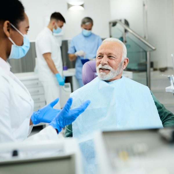 A dentist doing a checkup on a senior man