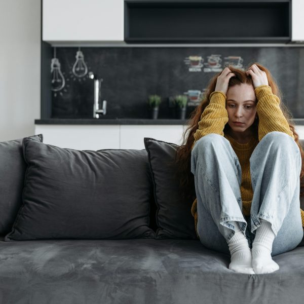 woman sitting on a couch, overthinking